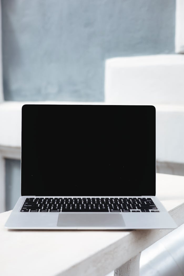 Home Showcase of a sleek laptop with a blank screen against a minimalist modern backdrop.
